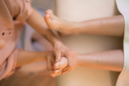 Eine Person, die eine Fußreflexzonenmassage erhält, um Schmerzen zu lindern und den Schlaf zu verbessern.